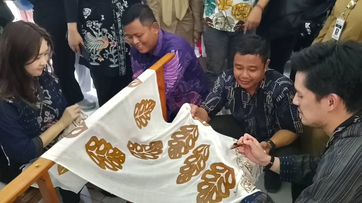 Artis Morgan Oey bersama owner jaringan toko  atik Benang Ratu, Maria Eunike Santoso mencoba praktik membatik. (Sumber:  | Foto: Sakti)